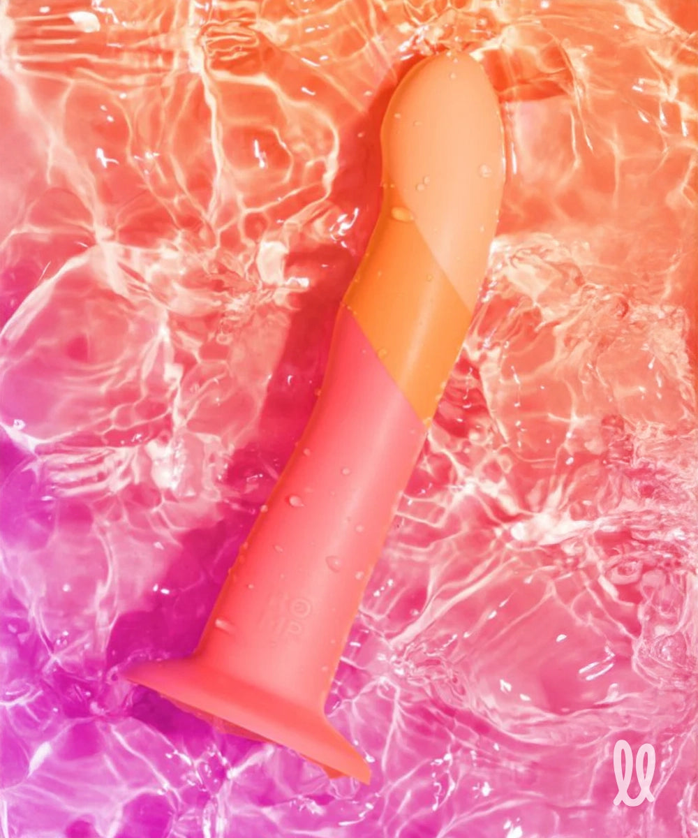 Colorful silicone dildo partially submerged in water with a gradient effect